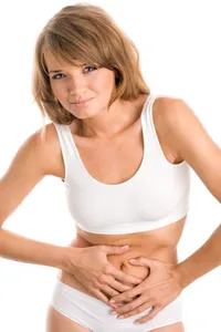 Illustration for a blog post about painful periods – a woman holding her aching abdomen.